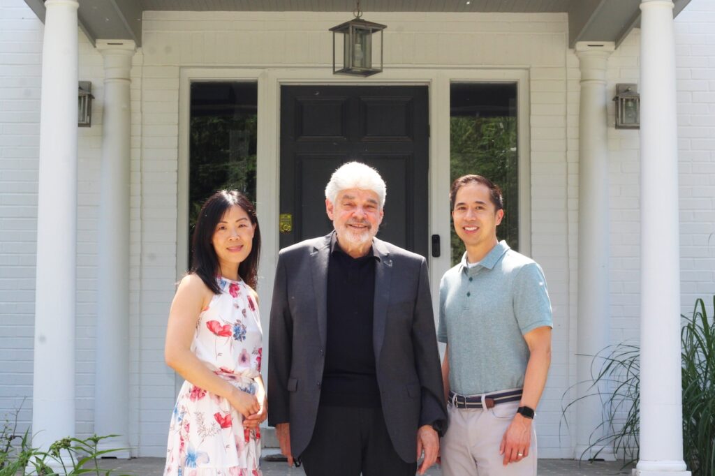 Founder Ira Fisher (middle) alongside current leadership Julie (left) and Moses Lee (right) in front of MLC in Ann Arbor